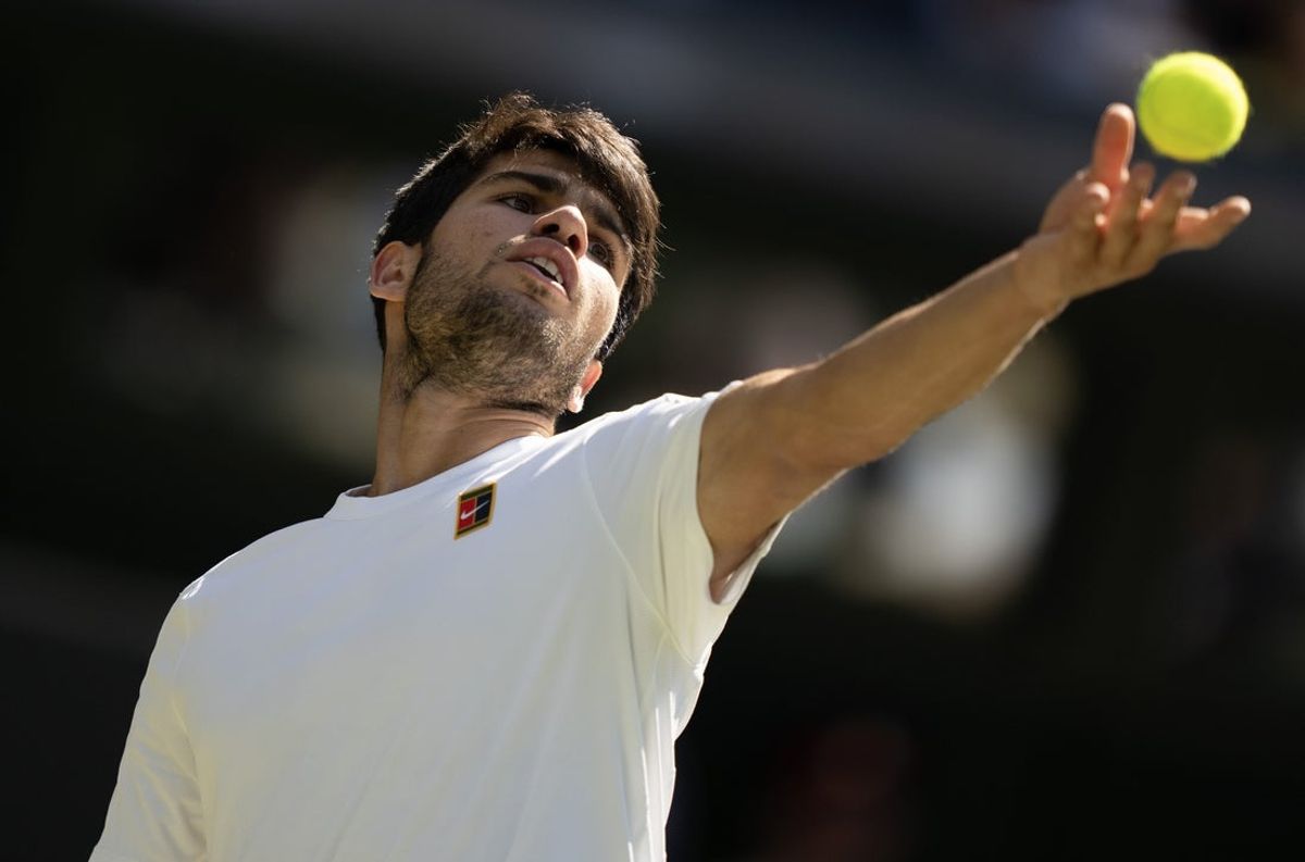 Jul 11, 2025; Wimbledon, United Kingdom; Carlos Alcaraz of Spain tosses the ball to serve during his match against Taylor Fritz of the United States on day 12 at All England Lawn Tennis and Croquet Club. Mandatory Credit: Susan Mullane-Imagn Images