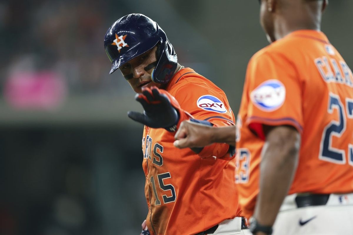 Jul 11, 2025; Houston, Texas, USA; Houston Astros third baseman Isaac Paredes (15) celebrates with first base coach Dave Clark (23) after hitting a single during the first inning against the Texas Rangers at Daikin Park. Mandatory Credit: Troy Taormina-Imagn Images
