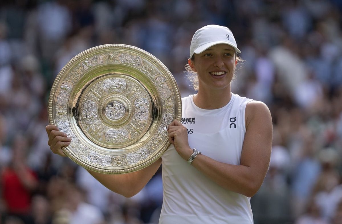 Jul 12, 2025; Wimbledon, United Kingdom; Iga Swiatek of Poland poses with the trophy after winning the women’s final match against Amanda Anisimova of the United States on day 13 at All England Lawn Tennis and Croquet Club. Mandatory Credit: Susan Mullane-Imagn Images