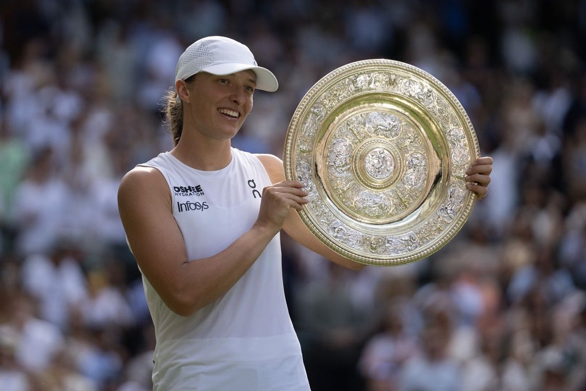 Jul 12, 2025; Wimbledon, United Kingdom; Iga Swiatek of Poland poses with the trophy after winning the women’s final match against Amanda Anisimova of the United States on day 13 at All England Lawn Tennis and Croquet Club. Mandatory Credit: Susan Mullane-Imagn Images