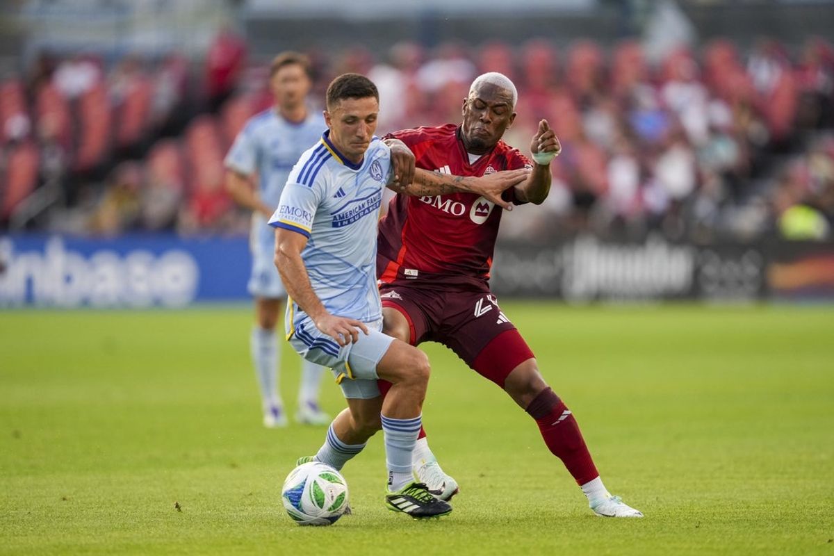 Jul 12, 2025; Toronto, Ontario, CAN; Atlanta United FC midfielder Bartosz Slisz (99) battles for the ball against Toronto FC midfielder Deybi Flores (20) during the first half at BMO Field. Mandatory Credit: Kevin Sousa-Imagn Images