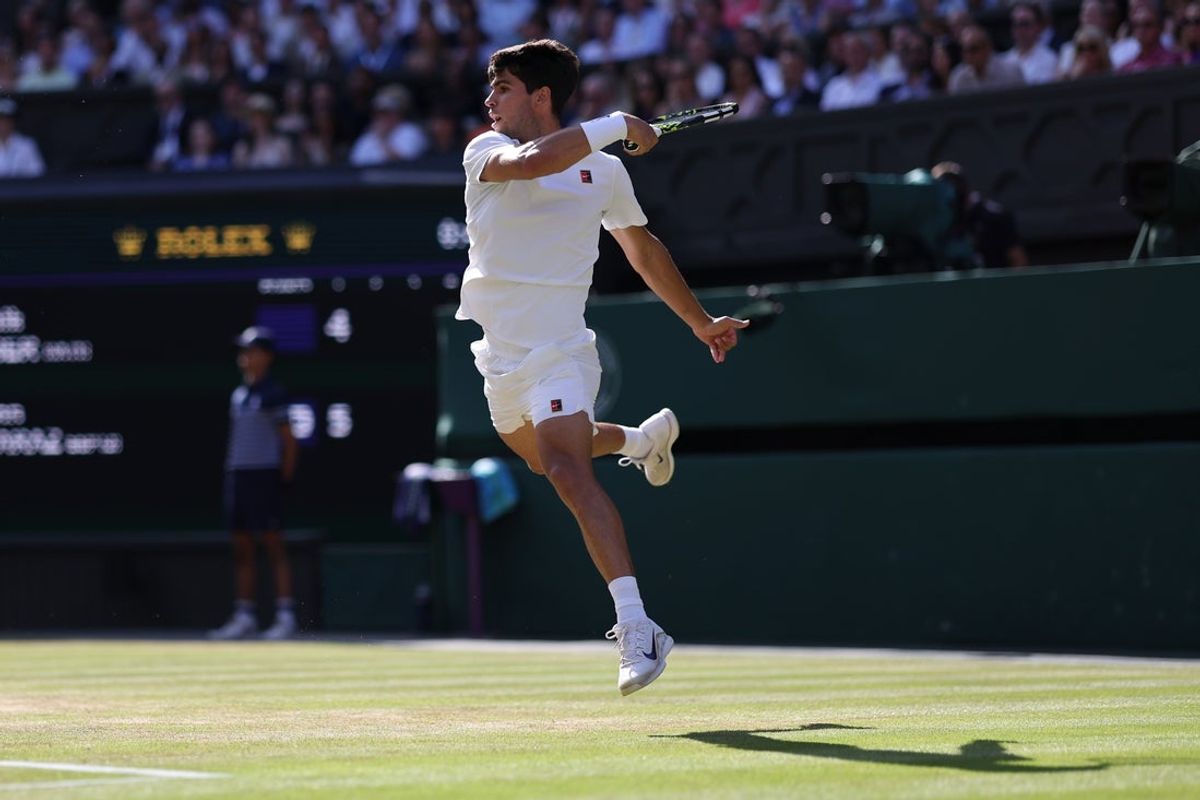 Jul 13, 2025; Wimbledon, United Kingdom; Carlos Alcaraz (ESP) hits a forehand against Jannik Sinner (ITA)(not pictured) in the gentlemen's' singles final of The Championships Wimbledon 2025 at All England Lawn Tennis and Croquet Club. Mandatory Credit: Geoff Burke-Imagn Images