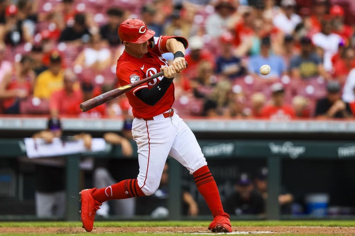 Jul 13, 2025; Cincinnati, Ohio, USA; Cincinnati Reds outfielder Austin Hays (12) hits a RBI single in the third inning against the Colorado Rockies at Great American Ball Park. Mandatory Credit: Katie Stratman-Imagn Images