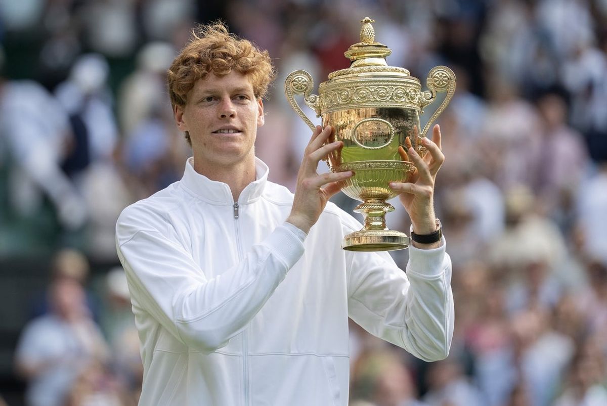 Jul 13, 2025; Wimbledon, United Kingdom; Jannik Sinner of Italy poses with the trophy after winning the men’s singles final match against Carlos Alcaraz of Spain on day 14 at All England Lawn Tennis and Croquet Club. Mandatory Credit: Susan Mullane-Imagn Images