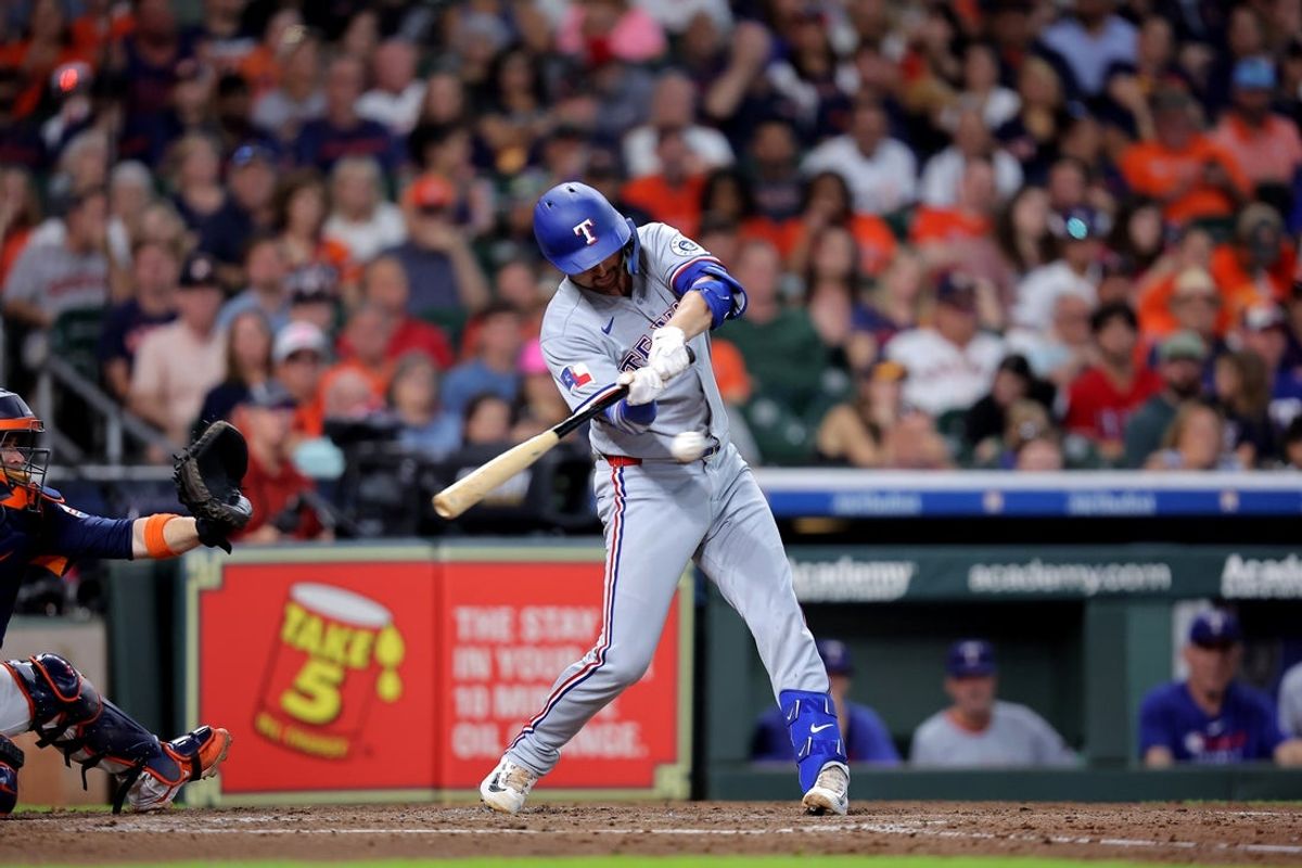 Jul 13, 2025; Houston, Texas, USA; Texas Rangers center fielder Evan Carter (32) hits a double against the Houston Astros during the fourth inning at Daikin Park. Mandatory Credit: Erik Williams-Imagn Images