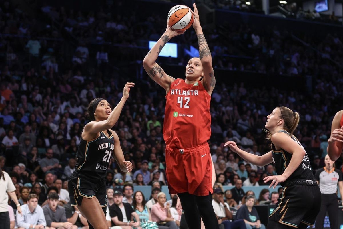 Jul 13, 2025; Brooklyn, New York, USA;  Atlanta Dream center Brittney Griner (42) drives past New York Liberty forward Isabelle Harrison (21) and guard Sabrina Ionescu (20) in the second quarter at Barclays Center. Mandatory Credit: Wendell Cruz-Imagn Images