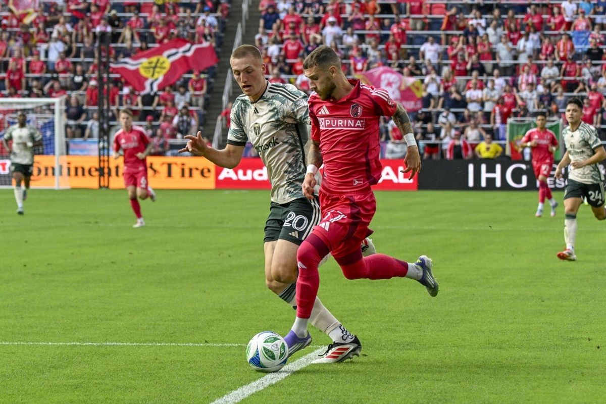 Jul 13, 2025; St. Louis, Missouri, USA; St. Louis City midfielder Marcel Hartel (17) controls the ball as Portland Timbers defender Finn Surman (20) pressures at Energizer Park. Mandatory Credit: Scott Rovak-Imagn Images