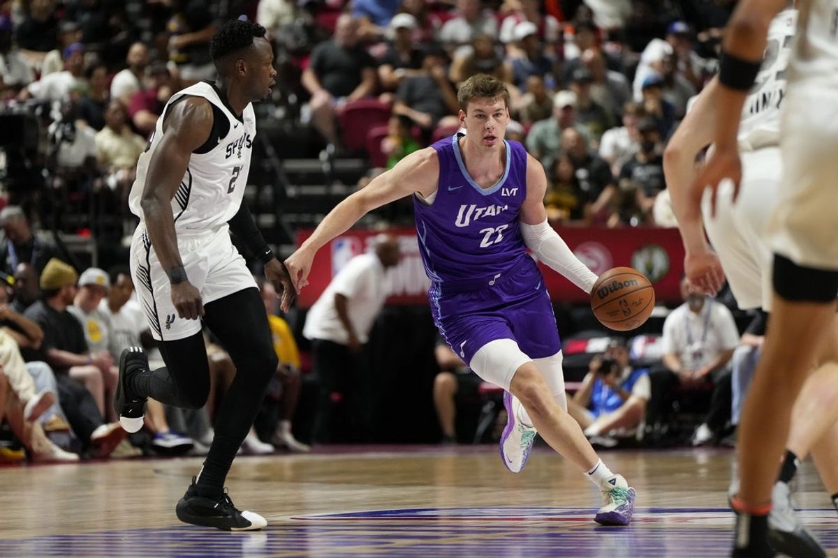 Jul 14, 2025; Las Vegas, NV, USA;  Utah Jazz forward Kyle Filipowski (22) dribbles the ball against San Antonio Spurs forward Osayi Osifo (26) during the first half of a NBA basketball game at Thomas & Mack Center. Mandatory Credit: Lucas Peltier-Imagn Images