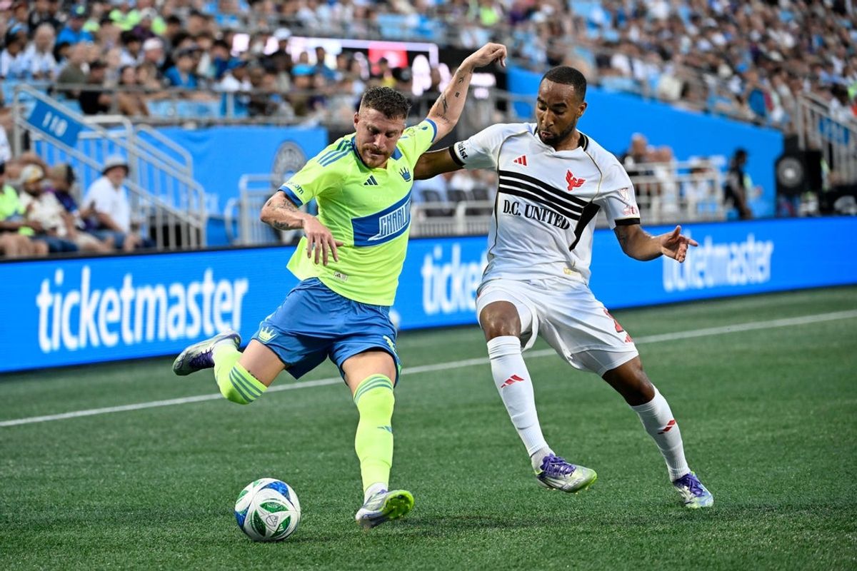 Jul 16, 2025; Charlotte, North Carolina, USA;  Charlotte FC midfielder Pep Biel (16) with the ball as D.C. United defender Derek Dodson (18) defends in the first half at Bank of America Stadium. Mandatory Credit: Bob Donnan-Imagn Images