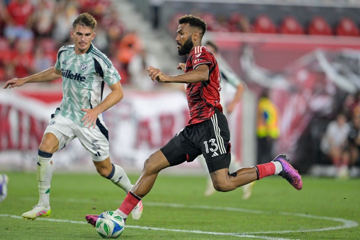 Jul 16, 2025; Harrison, New Jersey, USA; New York Red Bulls forward Eric Maxim Choupo-Moting (13) shoots the ball defended by New England Revolution defender Keegan Hughes (5) during the second half at Sports Illustrated Stadium. Mandatory Credit: Mark Smith-Imagn Images