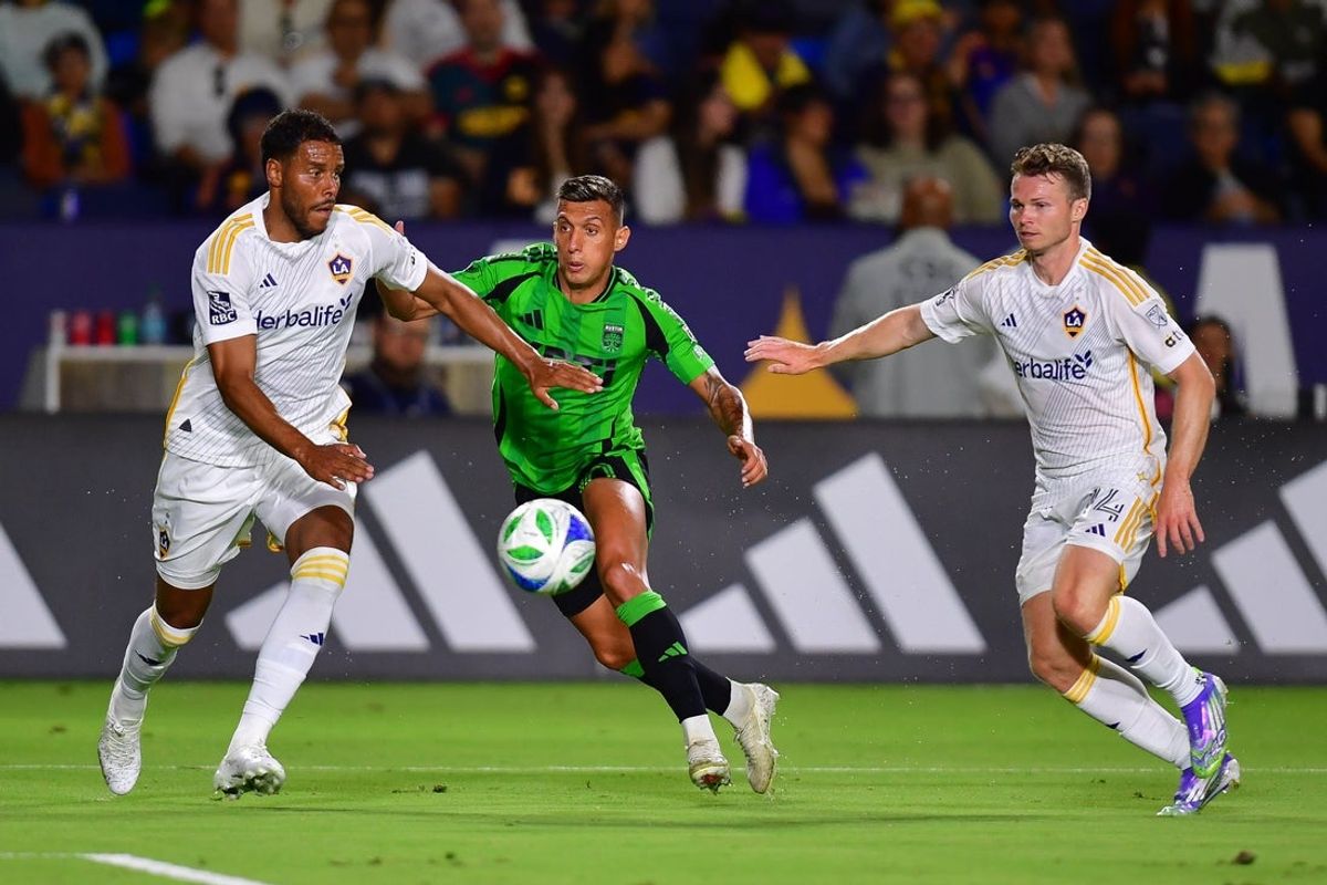 Jul 16, 2025; Carson, California, USA; LA Galaxy midfielder Isaiah Parente (16) and defender John Nelson (14) play for the ball against Austin FC forward Myrto Uzuni (10) during the second half at Dignity Health Sports Park. Mandatory Credit: Gary A. Vasquez-Imagn Images
