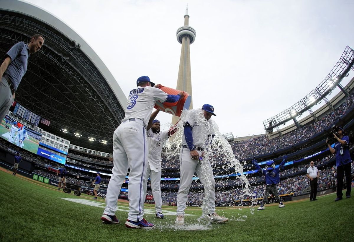 Jul 19, 2025; Toronto, Ontario, CAN; Toronto Blue Jays outfielder Myles Straw (3) and first baseman Vladimir Guerrero (27) dowse third baseman Will Wagner (7) with ice water after a win over the San Francisco Giants at Rogers Centre. Mandatory Credit: John E. Sokolowski-Imagn Images