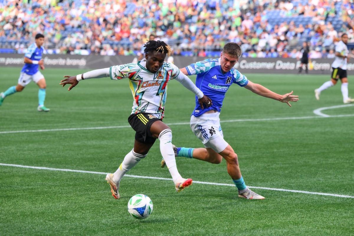 Jul 19, 2025; Seattle, Washington, USA; San Jose Earthquakes forward Ousseni Bouda (11) advances the ball while defended by Seattle Sounders FC midfielder Reed Baker-Whiting (21) during the first half at Lumen Field. Mandatory Credit: Steven Bisig-Imagn Images
