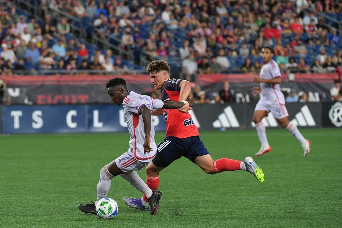 Jul 19, 2025; Foxborough, Massachusetts, USA; Orlando City forward Iván Angulo (77) and New England Revolution defender Ilay Feingold (12) battle for the ball during the second half at Gillette Stadium. Mandatory Credit: Bob DeChiara-Imagn Images