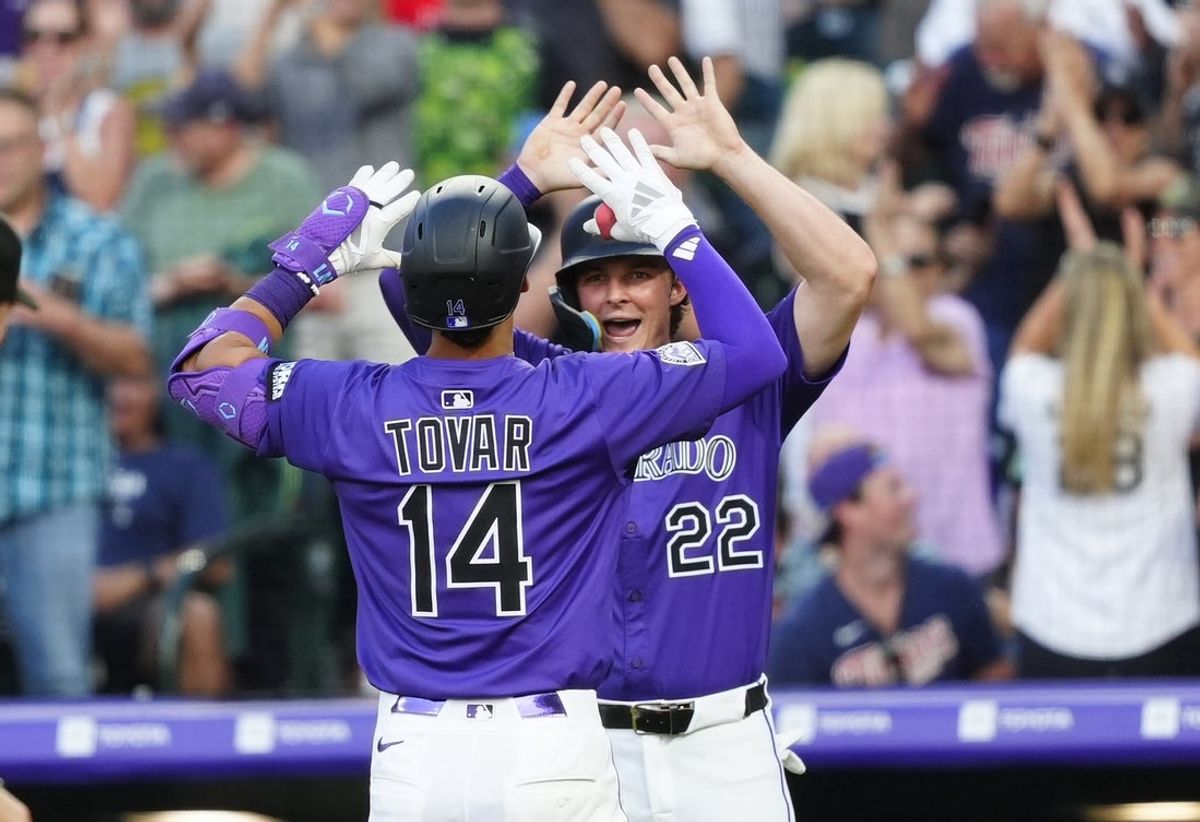 Jul 19, 2025; Denver, Colorado, USA; Colorado Rockies shortstop Ezequiel Tovar (14) celebrates his three-run home run with right fielder Mickey Moniak (22) in the fifth inning against the Minnesota Twins at Coors Field. Mandatory Credit: Ron Chenoy-Imagn Images
