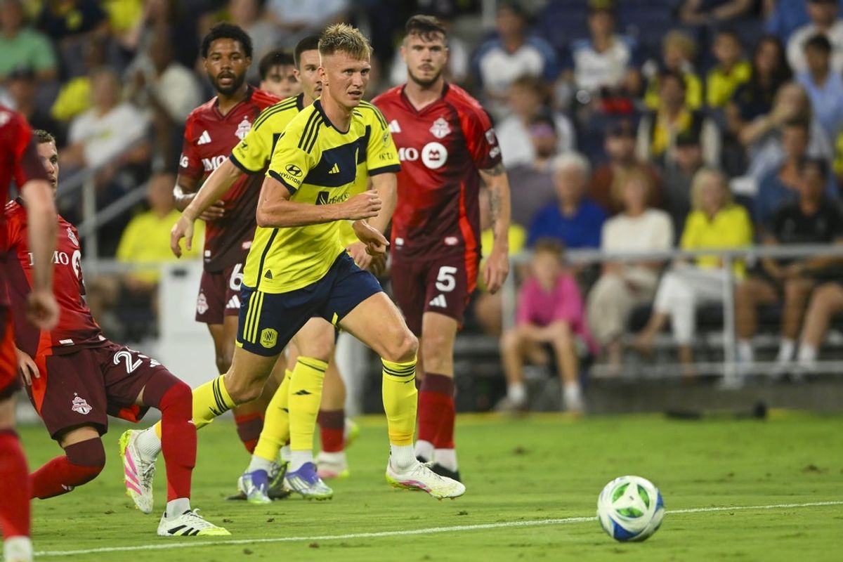 Jul 19, 2025; Nashville, Tennessee, USA;  Nashville SC forward Sam Surridge (9) dribbles the ball against the Toronto FC during the first half at Geodis Park. Mandatory Credit: Steve Roberts-Imagn Images