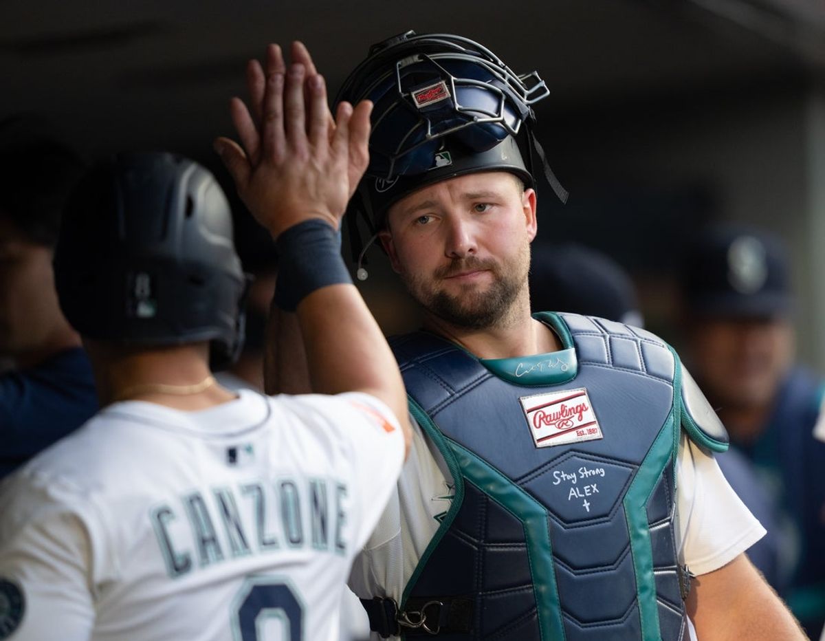 Jul 19, 2025; Seattle, Washington, USA;  Seattle Mariners right fielder Dominic Canzone (8), left, is congratulated by catcher Cal Raleigh (29) in the dugout after hitting a two-run double during the third inning against the Houston Astros at T-Mobile Park. Mandatory Credit: Stephen Brashear-Imagn Images