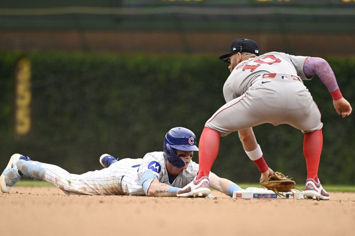 Jul 20, 2025; Chicago, Illinois, USA;  Chicago Cubs outfielder Pete Crow-Armstrong (4) dives into second base past Boston Red Sox shortstop Trevor Story (10) during the sixth inning at Wrigley Field. Mandatory Credit: Matt Marton-Imagn Images