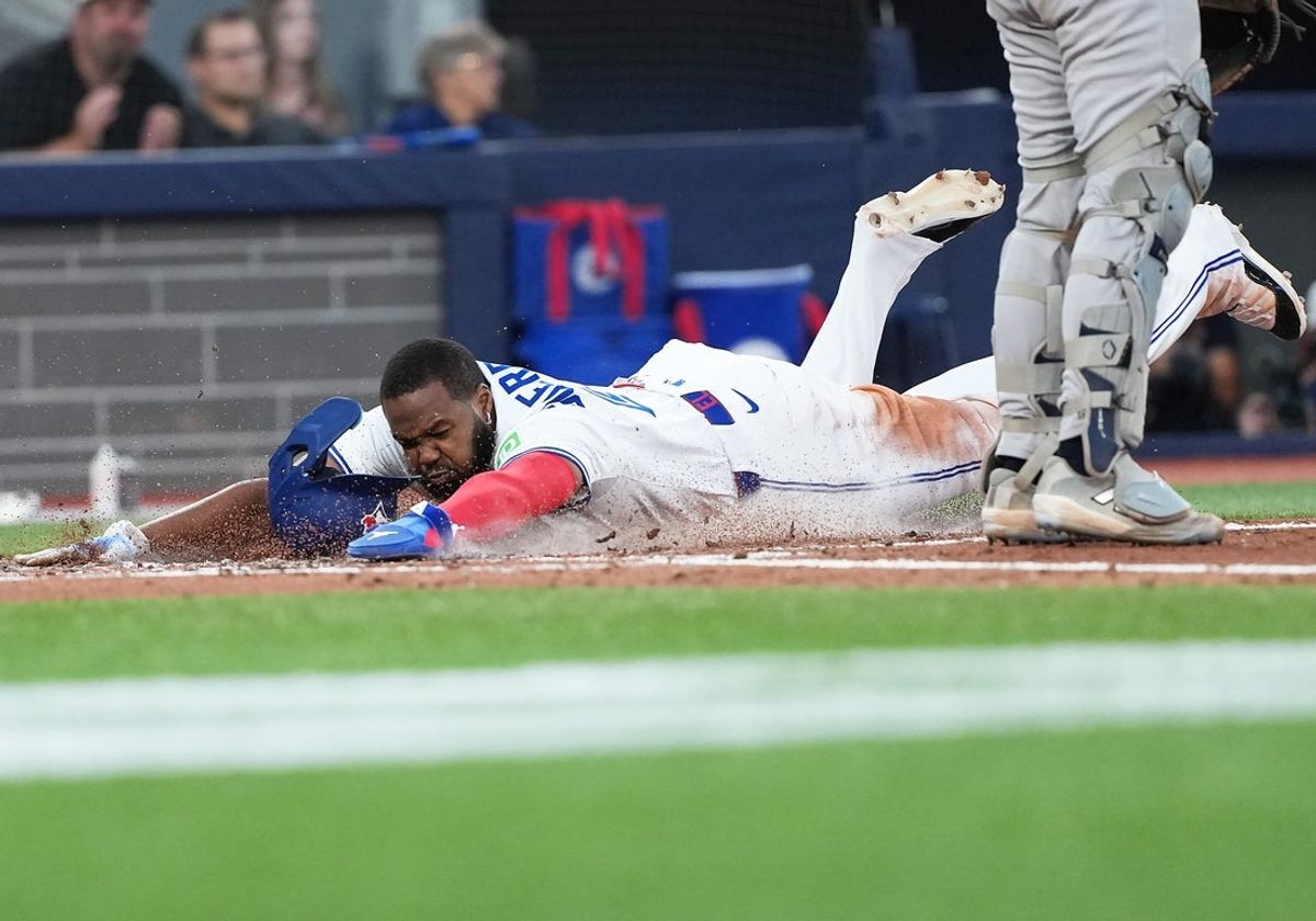 Jul 21, 2025; Toronto, Ontario, CAN;Toronto Blue Jays first baseman Vladimir Guerrero Jr. (27) slides into home plate scoring a run against the New York Yankees during the fifth inning at Rogers Centre. Mandatory Credit: Nick Turchiaro-Imagn Images