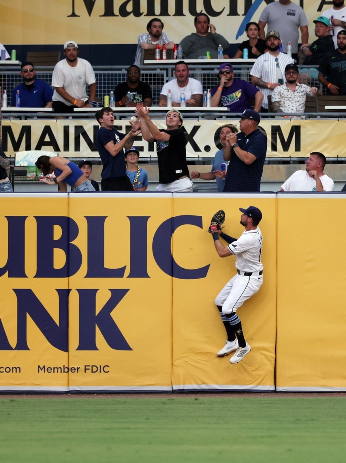 Jul 21, 2025; St. Petersburg, Florida, USA; Tampa Bay Rays outfielder Josh Lowe (15) jumps up on the outfield wall as a fan catches a home run ball from Chicago White Sox outfielder Brooks Baldwin (27) (not pictured)  during the second inning at George M. Steinbrenner Field. Mandatory Credit: Kim Klement Neitzel-Imagn Images