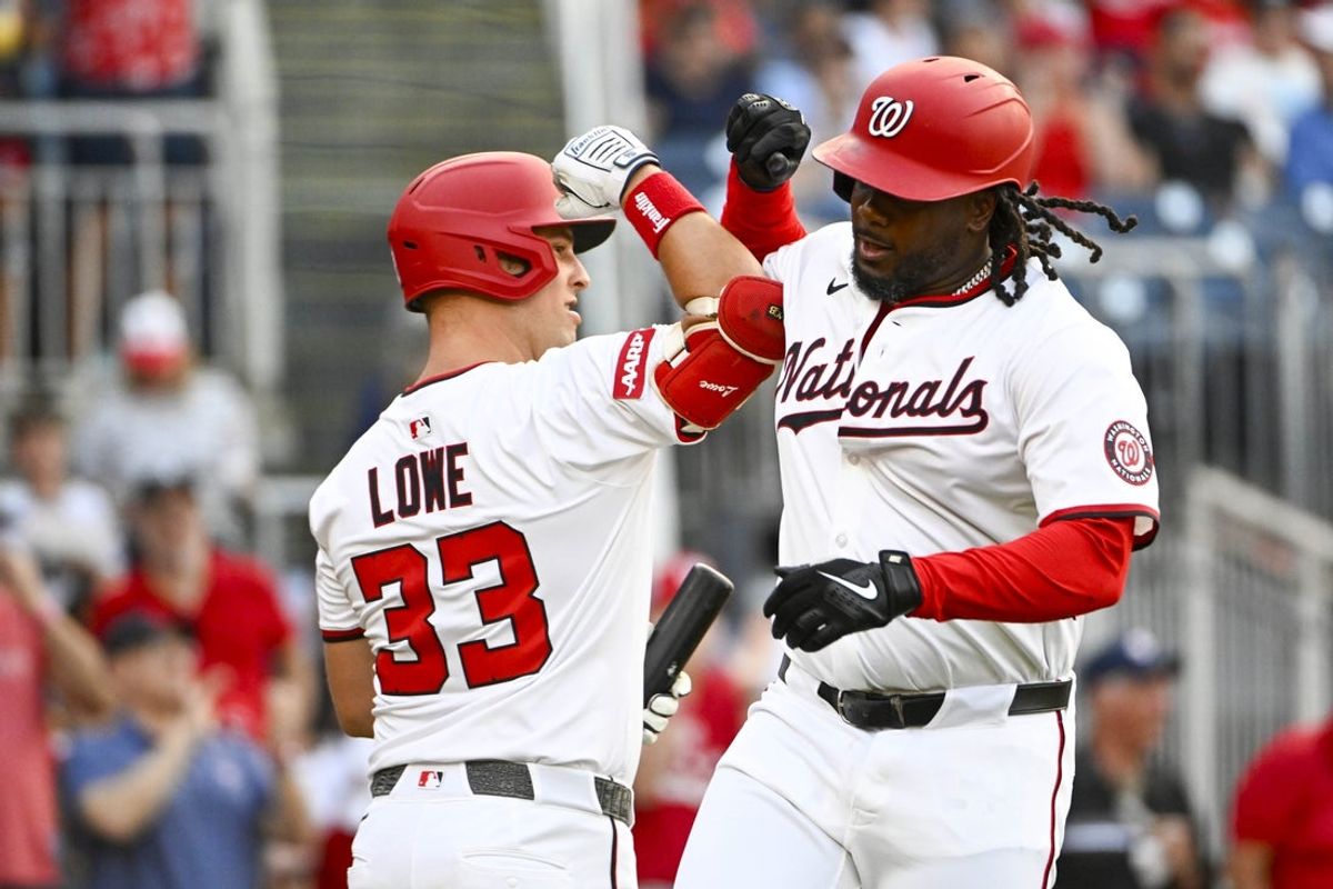 Jul 22, 2025; Washington, District of Columbia, USA; Washington Nationals designated hitter Josh Bell (19) is congratulated by first baseman Nathaniel Lowe (33) after hitting a solo home run against the Cincinnati Reds during the fourth inning at Nationals Park. Mandatory Credit: Brad Mills-Imagn Images