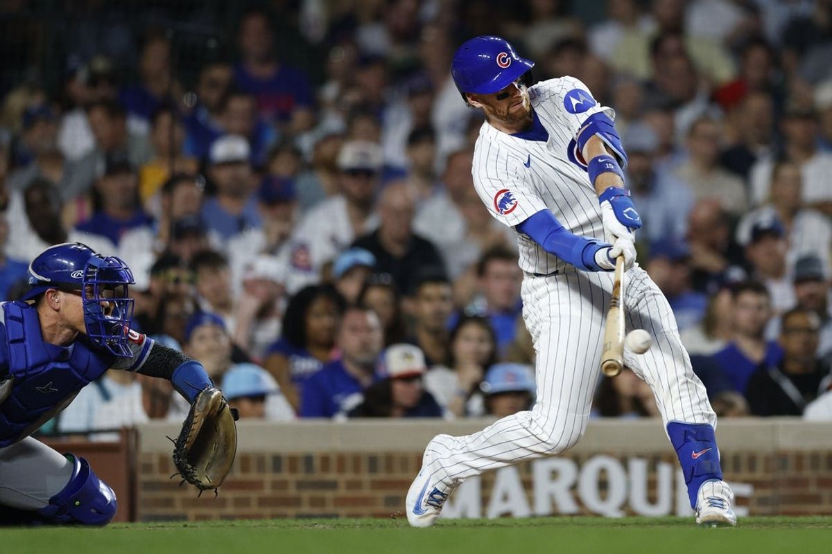Jul 22, 2025; Chicago, Illinois, USA; Chicago Cubs catcher Carson Kelly (15) singles against the Kansas City Royals during the fifth inning at Wrigley Field. Mandatory Credit: Kamil Krzaczynski-Imagn Images