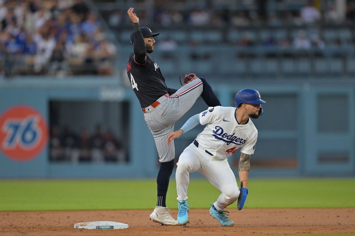 Jul 22, 2025; Los Angeles, California, USA; Minnesota Twins shortstop Carlos Correa (4) makes a throw to first base to get the out on Los Angeles Dodgers outfielder Andy Pages (44) in the second inning at Dodger Stadium. Mandatory Credit: Jayne Kamin-Oncea-Imagn Images