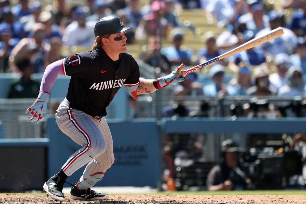 Jul 23, 2025; Los Angeles, California, USA;  Minnesota Twins pinch hitter Harrison Bader (12) hits an RBI single during the eighth inning against the Los Angeles Dodgers at Dodger Stadium. Mandatory Credit: Kiyoshi Mio-Imagn Images