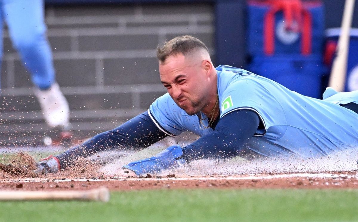 Jul 23, 2025; Toronto, Ontario, CAN;  Toronto Blue Jays designated hitter George Springer (4) slides home to score a run against the New York Yankees in the fourth inning at Rogers Centre. Mandatory Credit: Dan Hamilton-Imagn Images