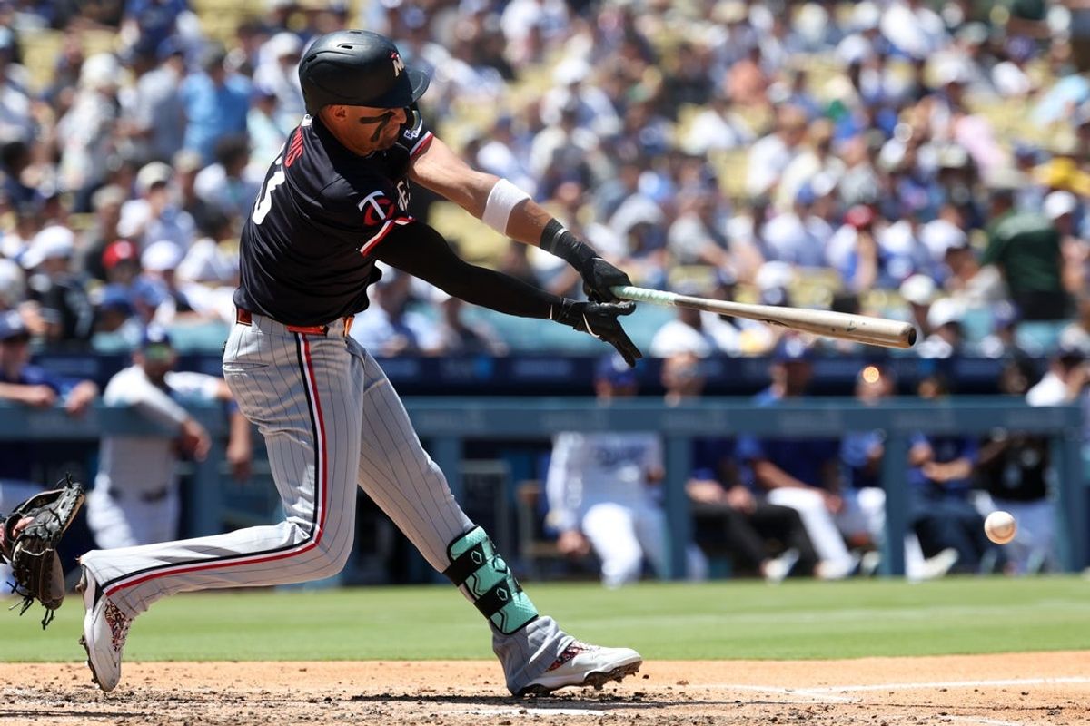 Jul 23, 2025; Los Angeles, California, USA;  Minnesota Twins third baseman Royce Lewis (23) hits a double during the fifth inning against the Los Angeles Dodgers at Dodger Stadium. Mandatory Credit: Kiyoshi Mio-Imagn Images