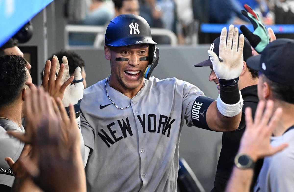 Jul 23, 2025; Toronto, Ontario, CAN;  New York Yankees designated hitter Aaron Judge (99) celebrates with team mates in the dugout after hitting a two run home run against the Toronto Blue Jays in the sixth inning at Rogers Centre. Mandatory Credit: Dan Hamilton-Imagn Images