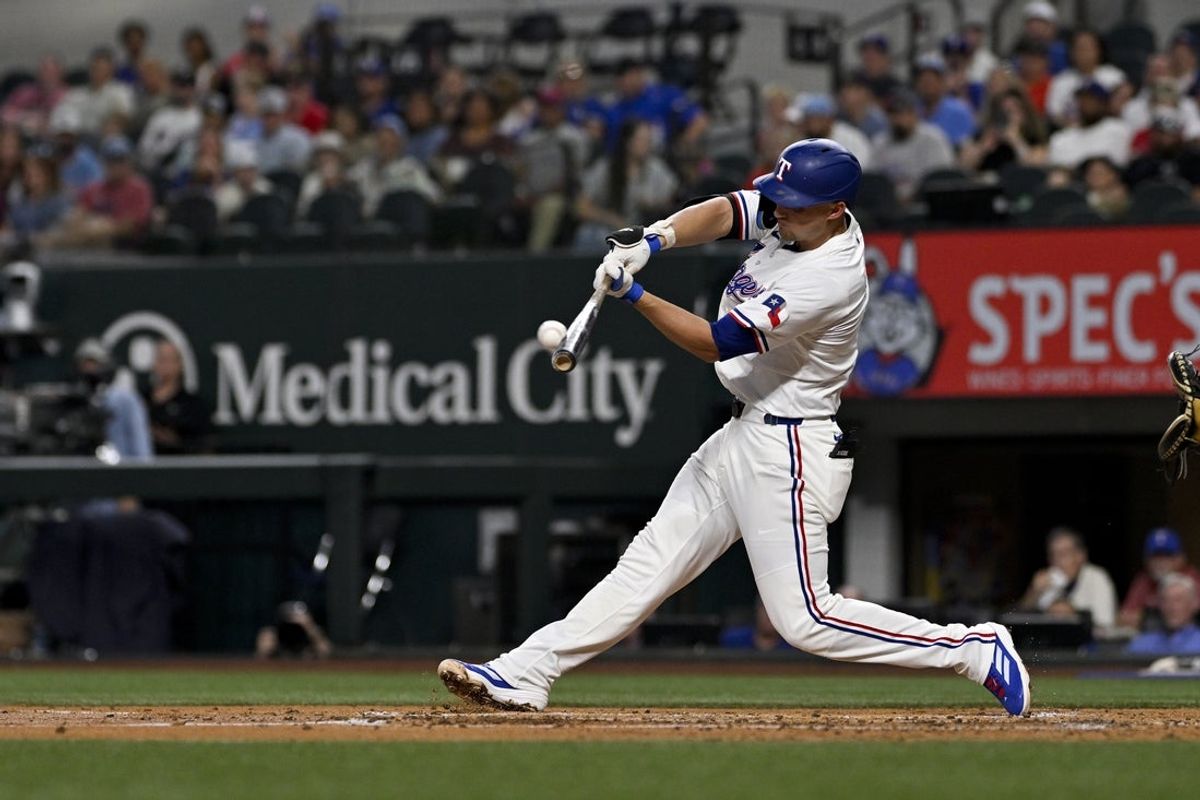 Jul 23, 2025; Arlington, Texas, USA; Texas Rangers shortstop Corey Seager (5) hits a home run against the Athletics during the third inning at Globe Life Field. Mandatory Credit: Jerome Miron-Imagn Images
