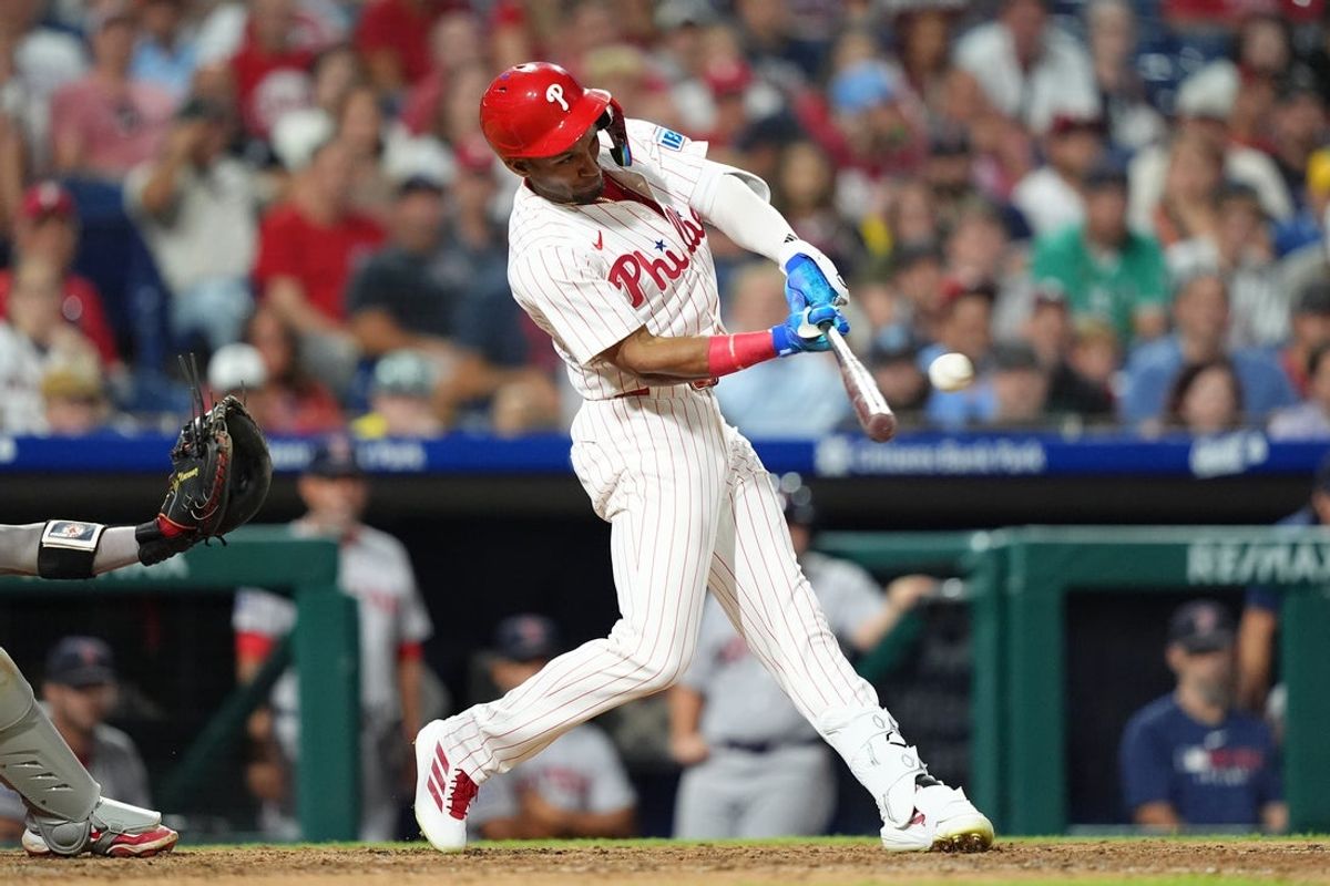 Jul 23, 2025; Philadelphia, Pennsylvania, USA; Philadelphia Phillies outfielder Johan Rojas (23) hits an RBI single against the Boston Red Sox in the eleventh inning at Citizens Bank Park. Mandatory Credit: Kyle Ross-Imagn Images