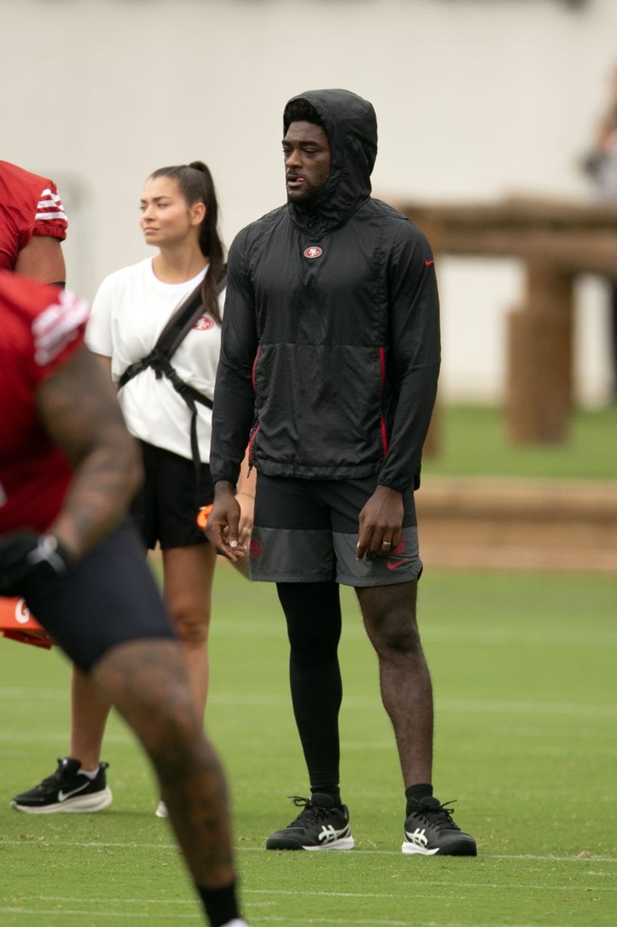 Jul 24, 2025; Santa Clara, CA, USA; San Francisco 49ers wide receiver Brandon Aiyuk (in black hoodie) watches his teammates work out during the second day of training camp. Mandatory Credit: D. Ross Cameron-Imagn Images