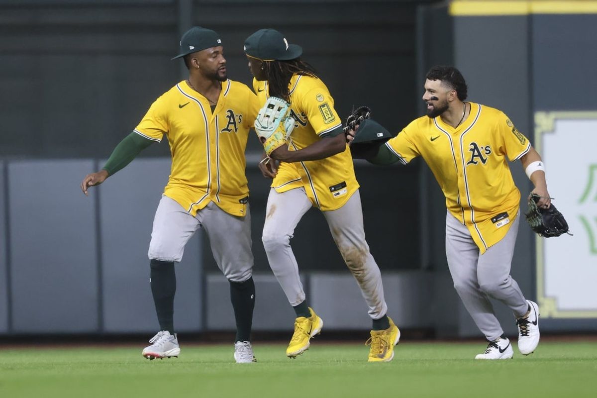 Jul 24, 2025; Houston, Texas, USA;  Athletics outfielders celebrate after the game against the Houston Astros at Daikin Park. Mandatory Credit: Troy Taormina-Imagn Images