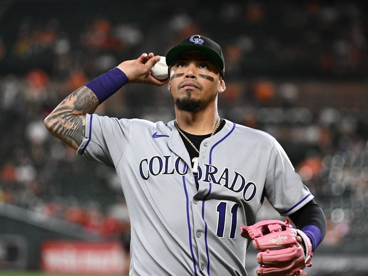 Jul 25, 2025; Baltimore, Maryland, USA;  Colorado Rockies third baseman Orlando Arcia (11) tosses a ball into the crowd during the eighth inning against the Baltimore Orioles at Oriole Park at Camden Yards. Mandatory Credit: James A. Pittman-Imagn Images