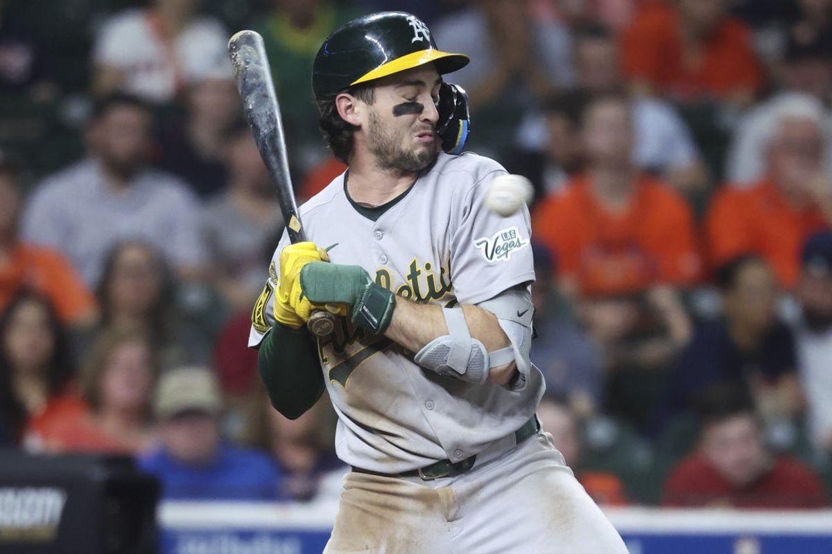 Jul 25, 2025; Houston, Texas, USA;  Athletics shortstop Jacob Wilson (5) reacts to an inside pitch during the sixth inning against the Houston Astros at Daikin Park. Mandatory Credit: Troy Taormina-Imagn Images