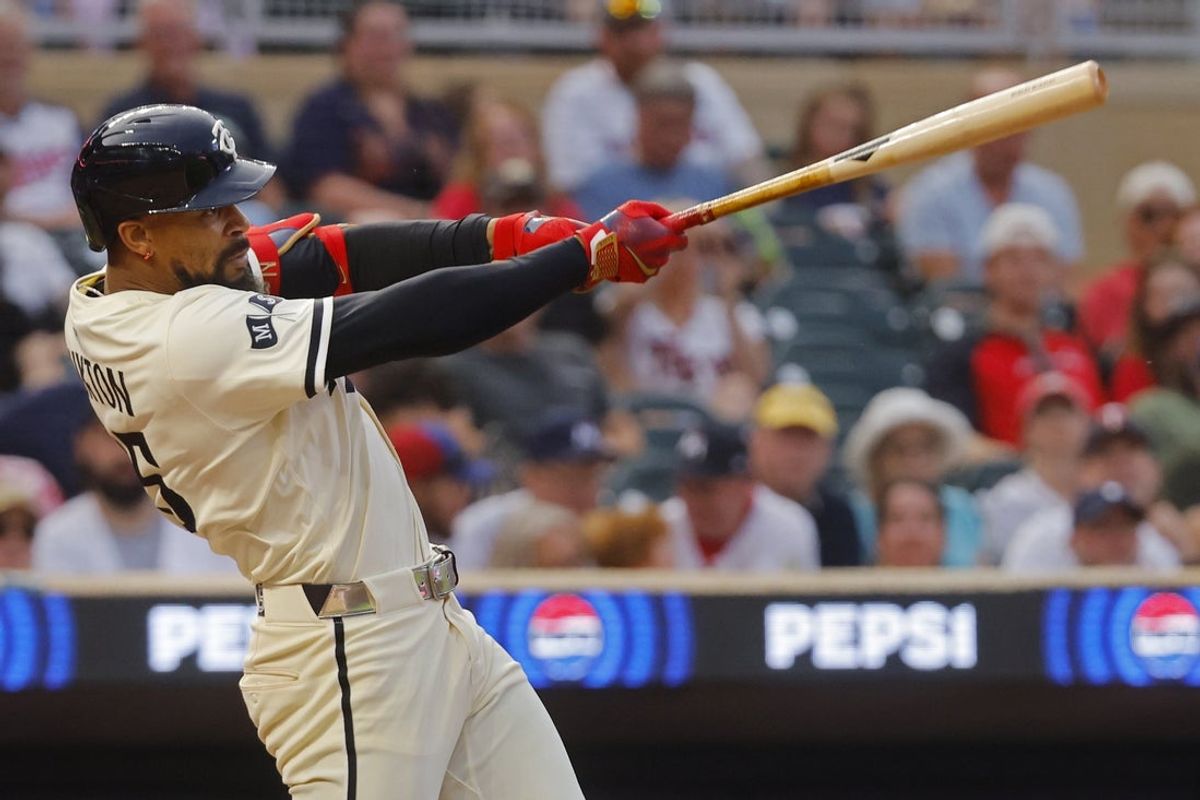 Jul 25, 2025; Minneapolis, Minnesota, USA; Minnesota Twins center fielder Byron Buxton (25) hits a sacrifice fly against the Washington Nationals in the fifth inning at Target Field. Mandatory Credit: Bruce Kluckhohn-Imagn Images