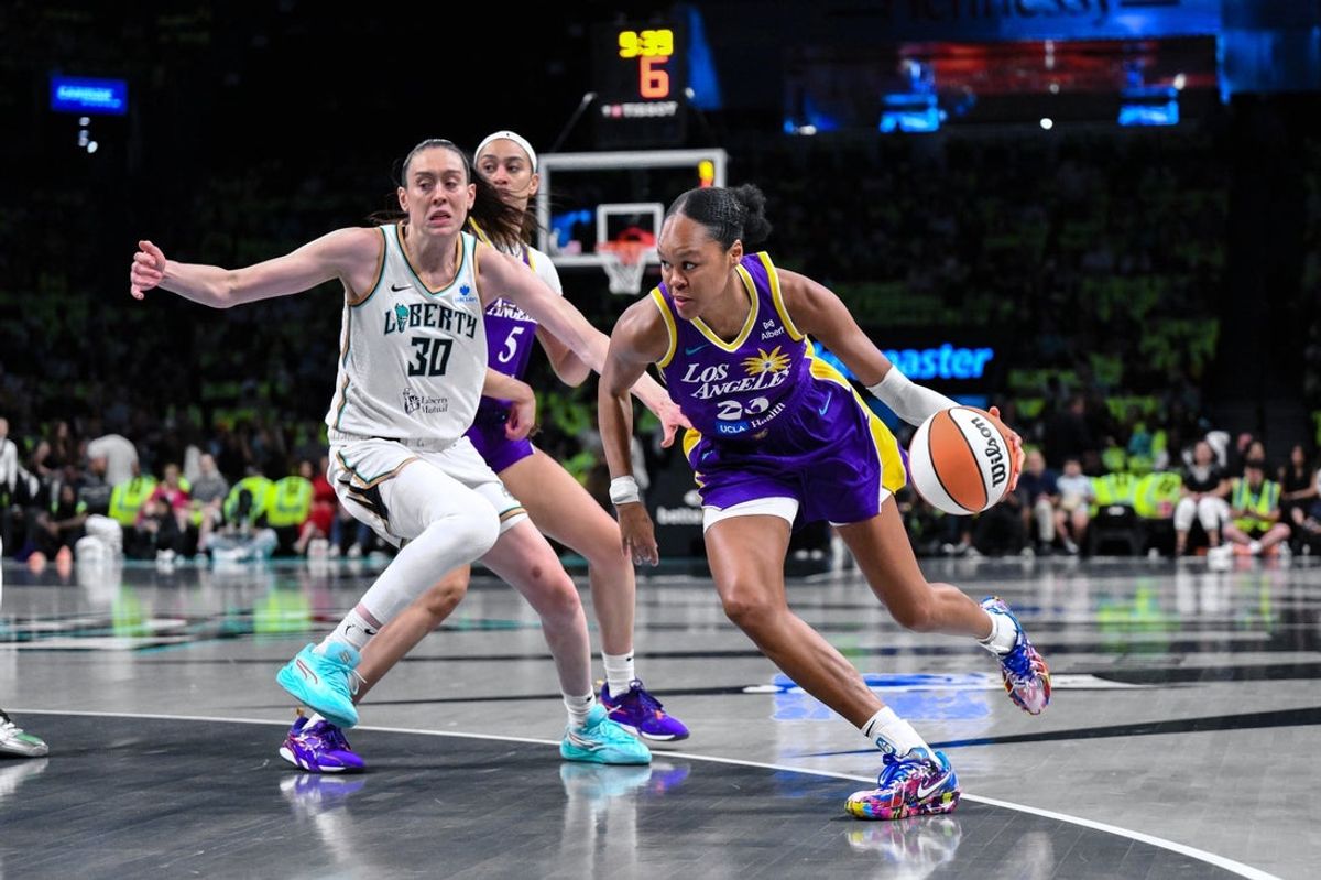 Jul 26, 2025; Brooklyn, New York, USA; Los Angeles Sparks forward Azura Stevens (23) drives past New York Liberty forward Breanna Stewart (30) during the first half at Barclays Center. Mandatory Credit: John Jones-Imagn Images
