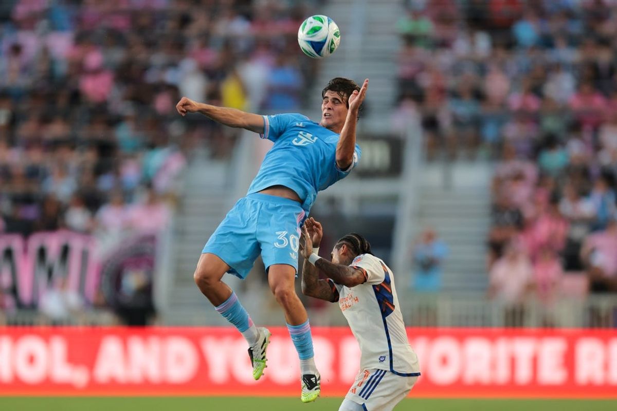Jul 26, 2025; Fort Lauderdale, Florida, USA; Inter Miami CF midfielder Benjamin Cremaschi (30) jumps for a header against FC Cincinnati defender DeAndre Yedlin (91) during the first half at Chase Stadium. Mandatory Credit: Sam Navarro-Imagn Images