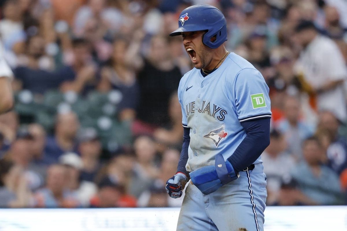 Jul 26, 2025; Detroit, Michigan, USA;  Toronto Blue Jays outfielder George Springer (4) celebrates after he dives in safe at home in the eighth inning against the Detroit Tigers at Comerica Park. Mandatory Credit: Rick Osentoski-Imagn Images