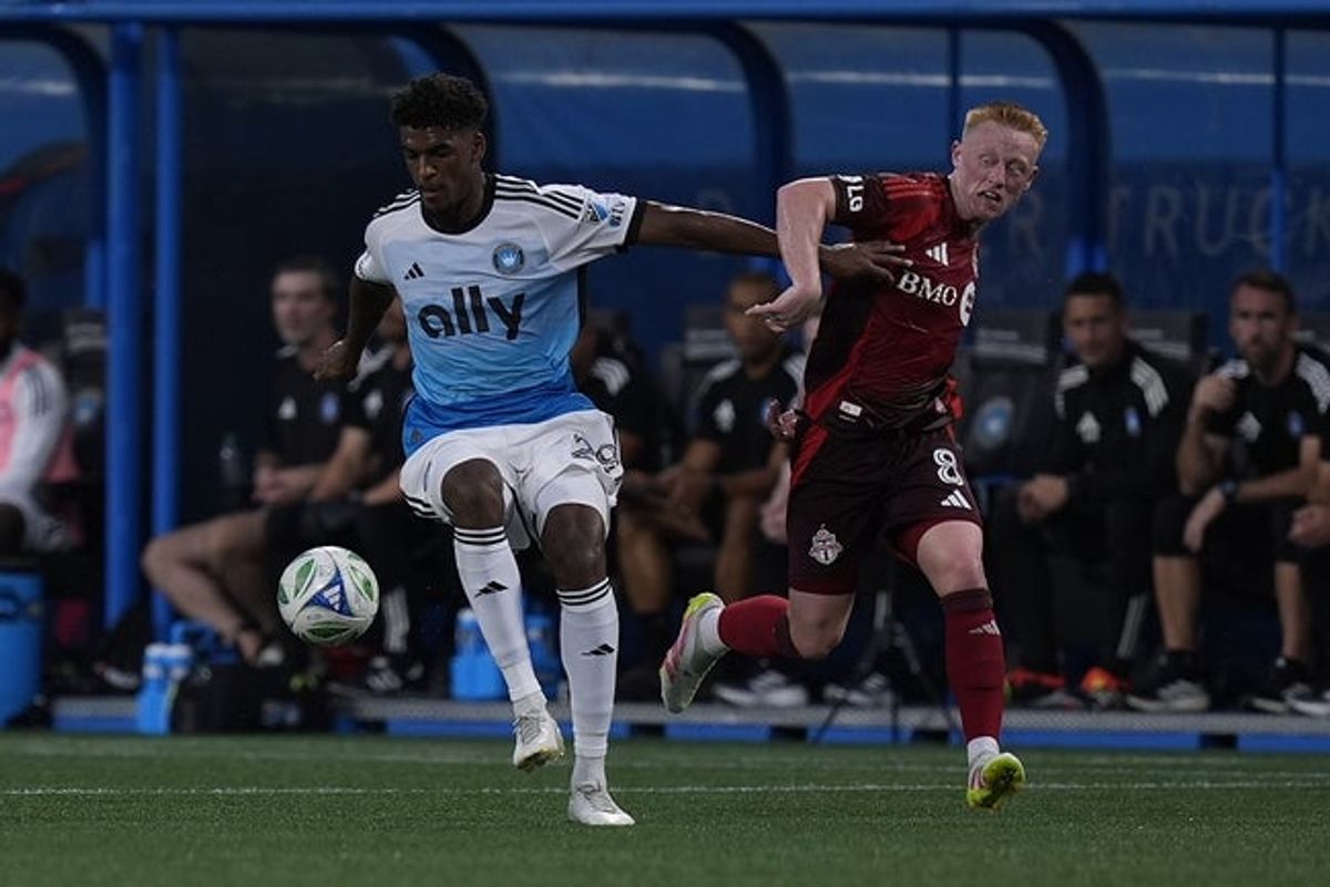 Jul 26, 2025; Charlotte, North Carolina, USA; Charlotte FC defender Adilson Malanda (29) gets control from Toronto FC midfielder Matthew Longstaff (8) during the first half at Bank of America Stadium. Mandatory Credit: Jim Dedmon-Imagn Images