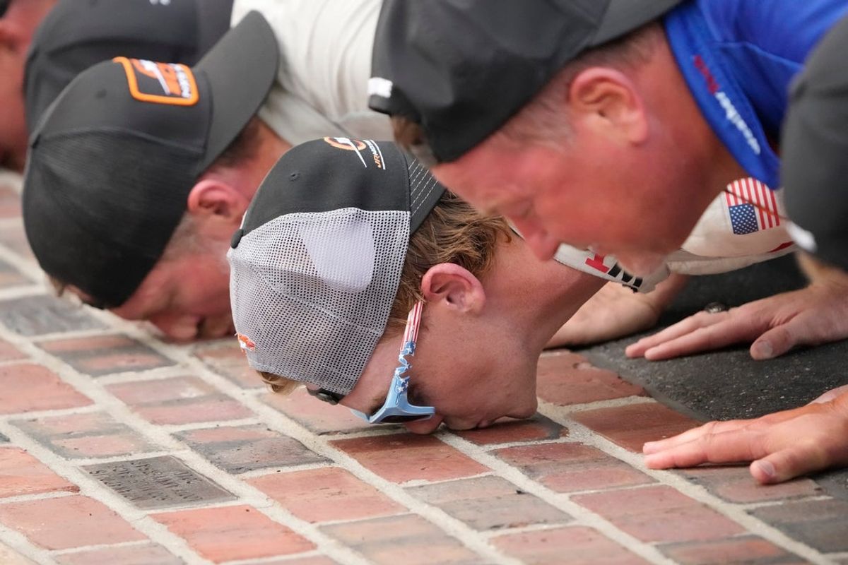 NASCAR Xfinity Series driver Connor Zilisch (88) kisses the bricks Saturday, July 26, 2025, following his win in the Pennzoil 250 at Indianapolis Motor Speedway.