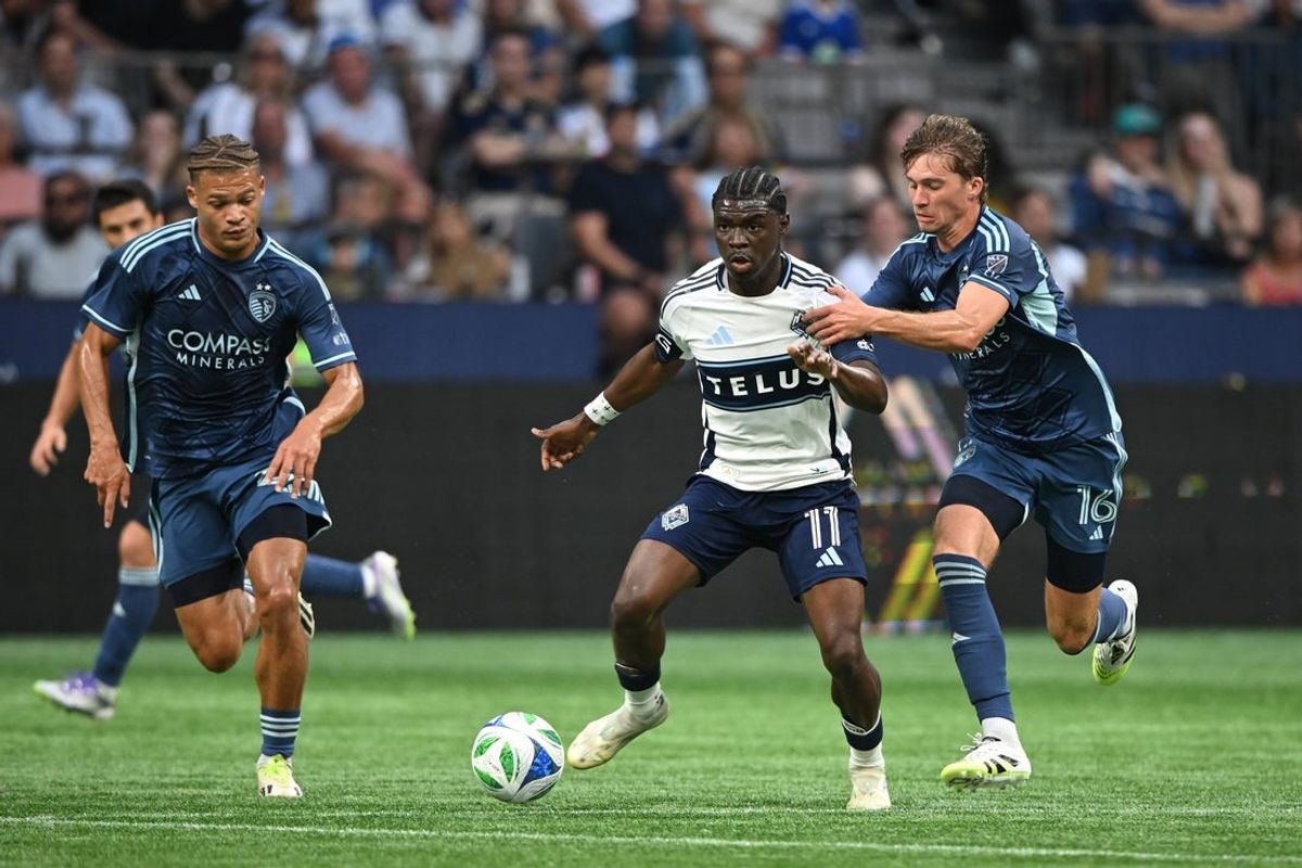 Jul 26, 2025; Vancouver, British Columbia, CAN;  Vancouver Whitecaps FC forward Emmanuel Sabbi (11) controls the ball against Sporting Kansas City midfielder Jacob Bartlett (16) during the first half at BC Place. Mandatory Credit: Anne-Marie Sorvin-Imagn Images