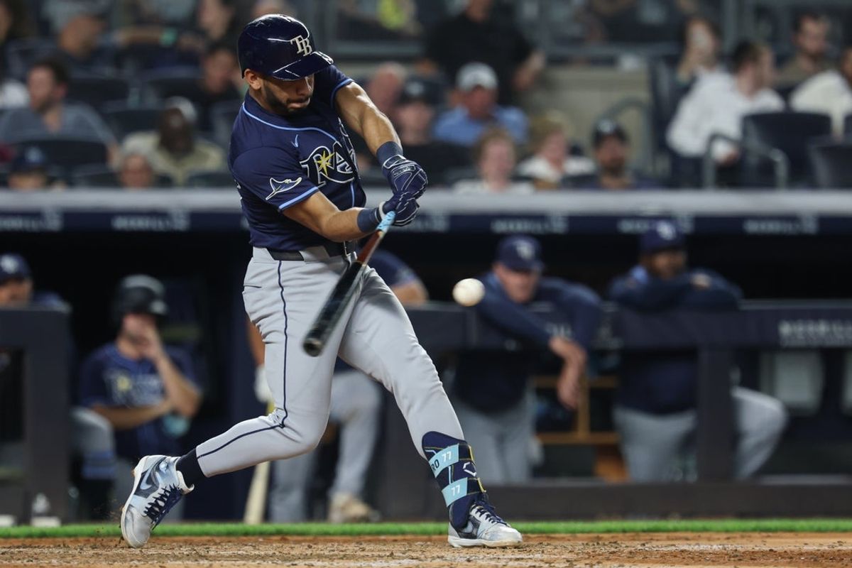 Jul 28, 2025; Bronx, New York, USA; Tampa Bay Rays shortstop Jose Caballero (77) hits an infield single during the eighth inning against the New York Yankees at Yankee Stadium. Mandatory Credit: Vincent Carchietta-Imagn Images