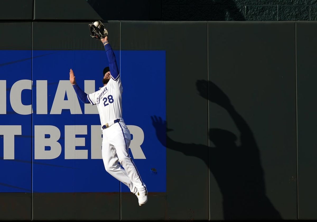 Jul 29, 2025; Kansas City, Missouri, USA; Kansas City Royals center fielder Kyle Isbel (28) makes a leaping catch at the wall during the first inning against the Atlanta Braves at Kauffman Stadium. Mandatory Credit: Jay Biggerstaff-Imagn Images