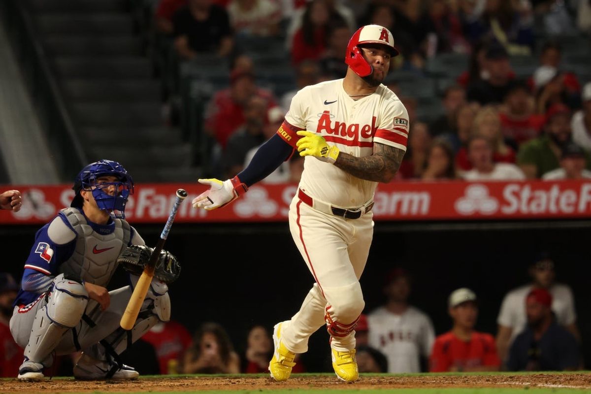 Jul 29, 2025; Anaheim, California, USA;  Los Angeles Angels pinch hitter Yoan Moncada (5) hits an RBI single during the sixth inning against the Texas Rangers at Angel Stadium. Mandatory Credit: Kiyoshi Mio-Imagn Images