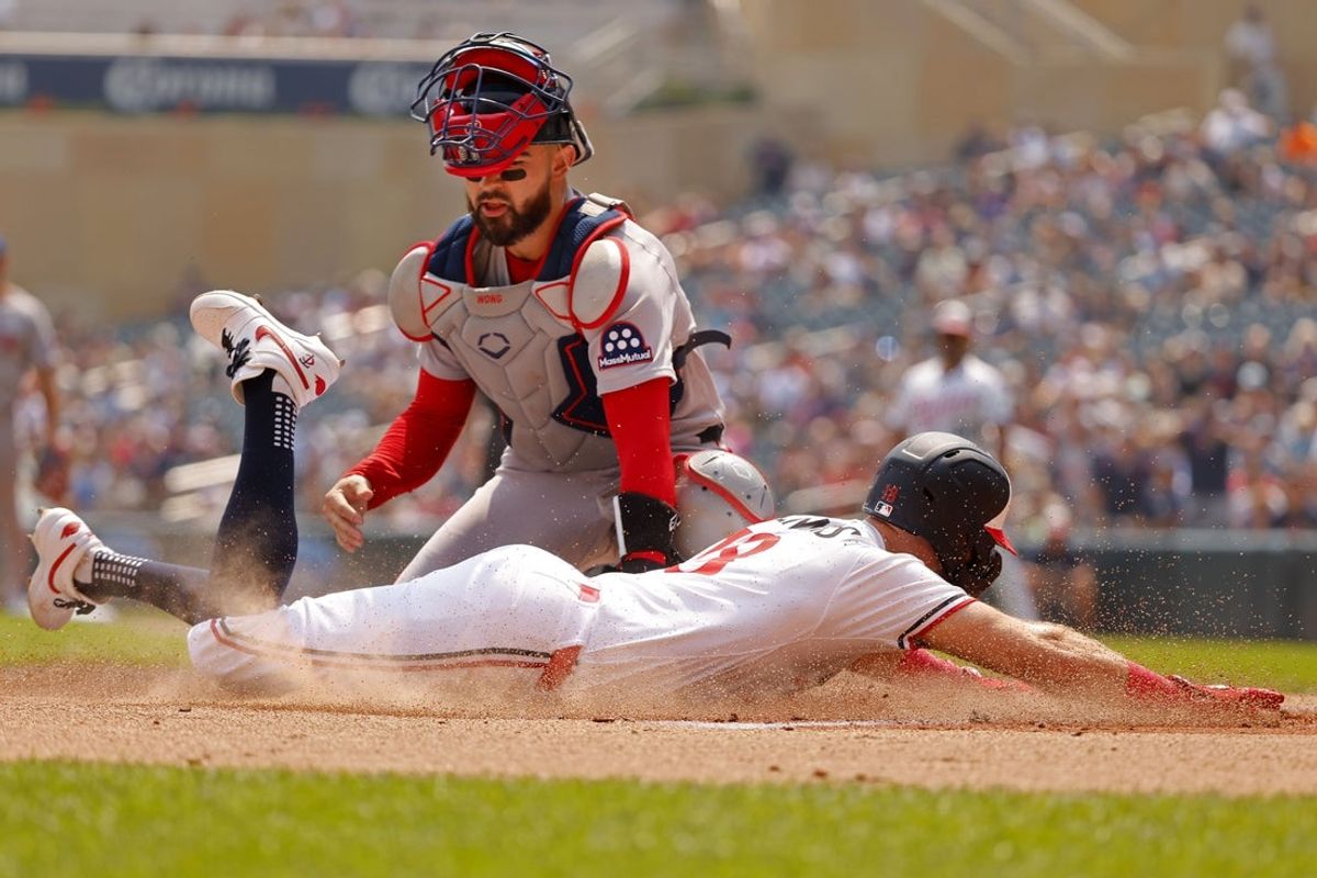 Jul 30, 2025; Minneapolis, Minnesota, USA; Boston Red Sox catcher Connor Wong (12) tags out Minnesota Twins first baseman Kody Clemens (18) who tries to score from first base on a catcher Ryan Jeffers (not pictured) single in the first inning at Target Field. Mandatory Credit: Bruce Kluckhohn-Imagn Images