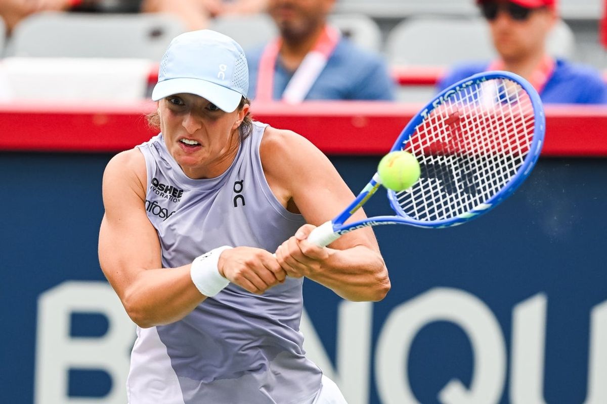 Jul 30, 2025; Montreal, QC, Canada; Iga Swiatek (POL) returns the ball to Hanyu Guo (CHN) in second round play at IGA Stadium. Mandatory Credit: David Kirouac-Imagn Images