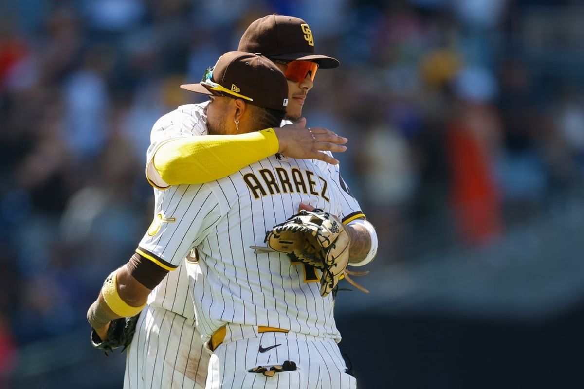 Jul 30, 2025; San Diego, California, USA; San Diego Padres third baseman Manny Machado (13) hugs first baseman Luis Arraez (4) after defeating the New York Mets at Petco Park. Mandatory Credit: David Frerker-Imagn Images